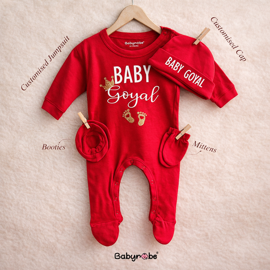 Red baby onesie with matching hat, booties, and mittens on a beige background, branded 'Babynrobe'.