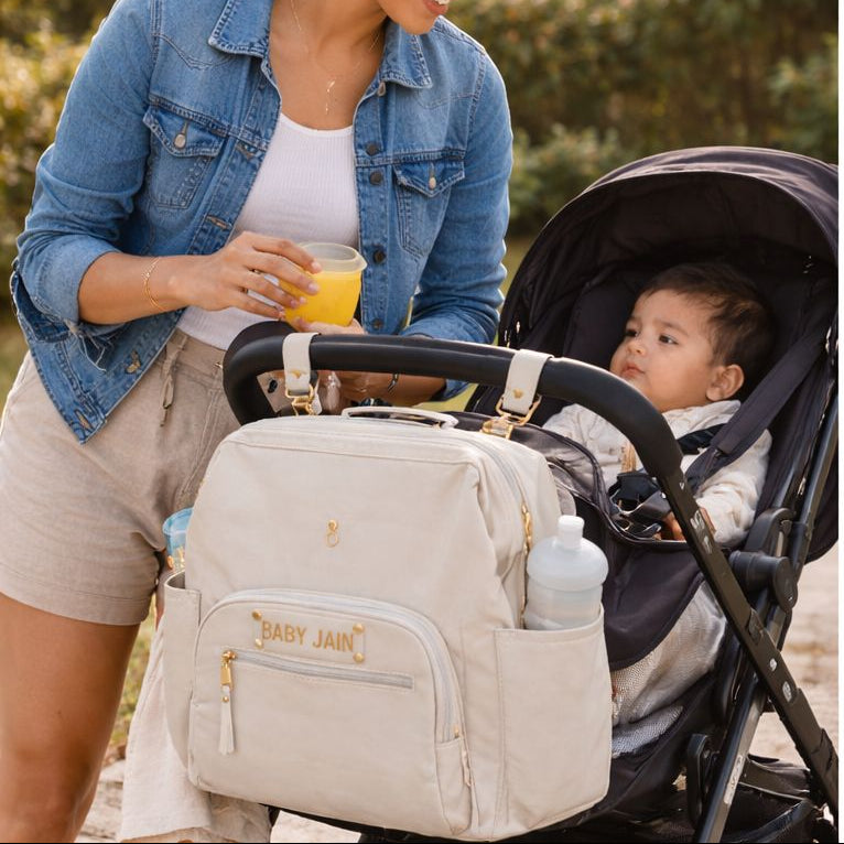 Two women with strollers and baby bags in a natural setting