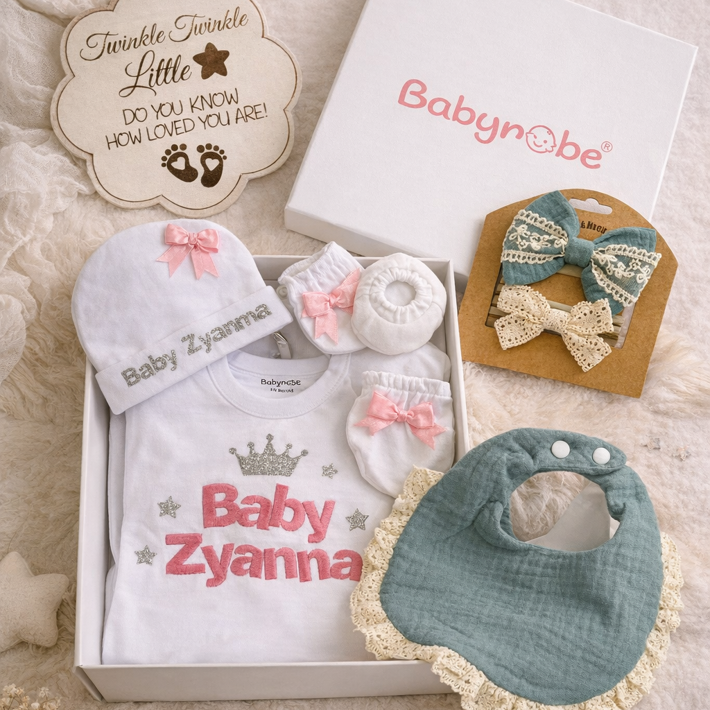 Baby gift set with personalized items and 'Babyn'be' packaging on a textured surface.