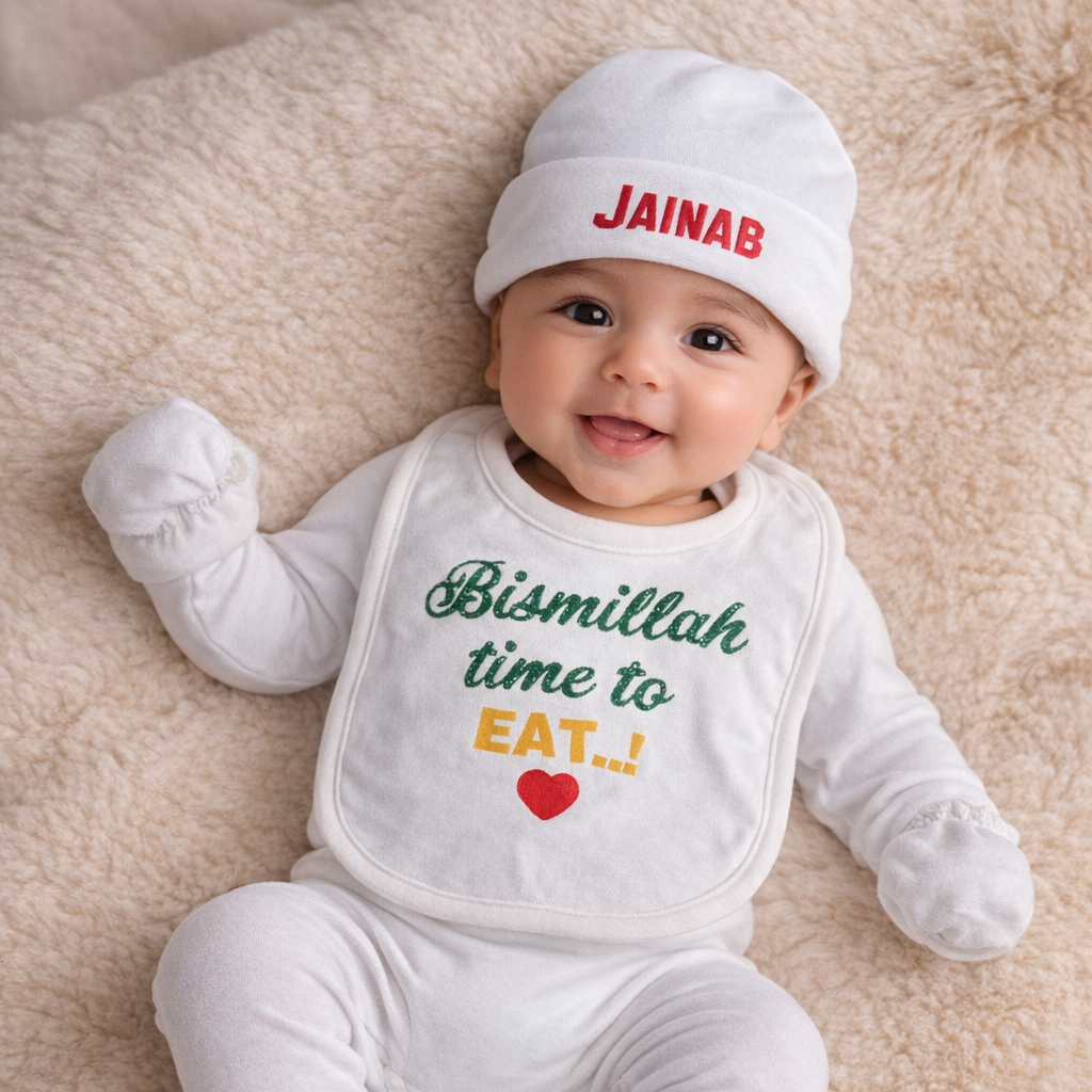 Baby wearing a white outfit with text and a cap on a beige blanket