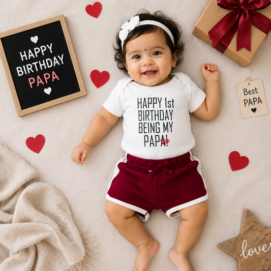 Baby wearing a 'Happy 1st Birthday Being My Papa' shirt surrounded by birthday decorations.