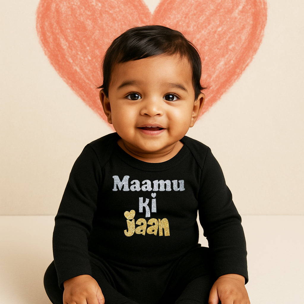Baby wearing a black onesie with text, sitting in front of a heart-shaped balloon.