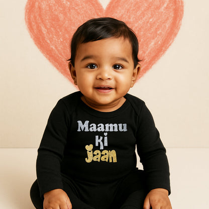 Baby wearing a black onesie with text, sitting in front of a heart-shaped balloon.