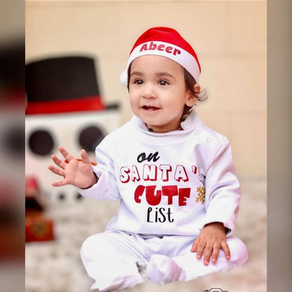 Child wearing a Santa outfit with text and a snowman in the background